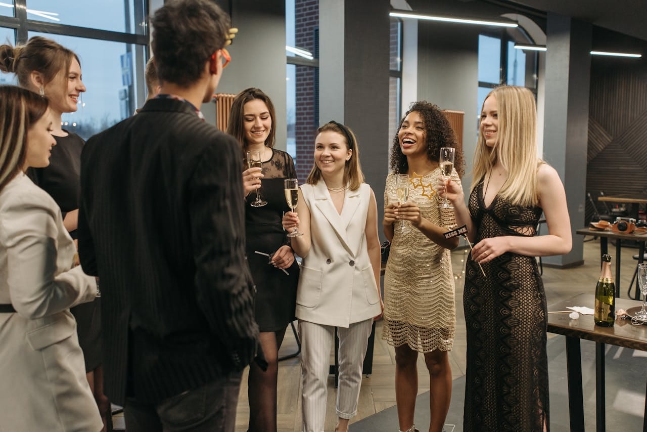 A diverse group of colleagues celebrating with drinks indoors, showcasing diversity and camaraderie.