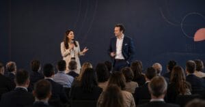 Two conference speakers discussing event industry trends with an audience of event and business professionals